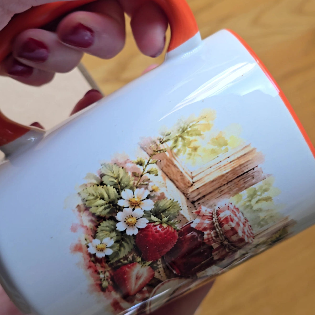 Back of the Buttered Toast mug showing strawberries, daisies and jam jars, orange handle